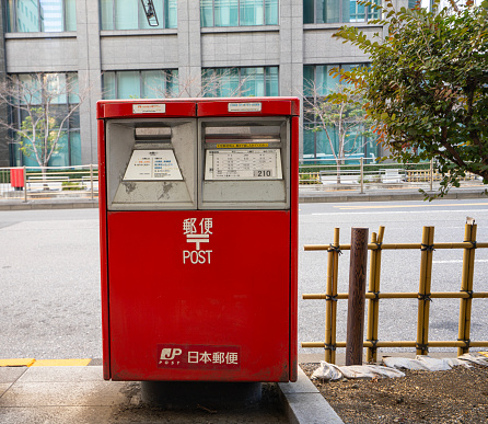 Tokyo, Japan, January 2024. a Japanese post mailbox on the sidewalk of a city center street