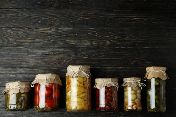 istock Jars of pickled vegetables on rustic wooden background 1934101366