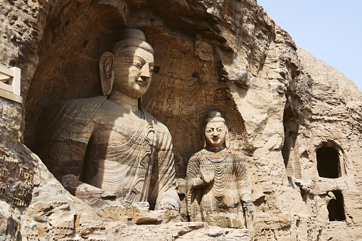Stone Buddha at Yungang Grottoes, ancient Chinese Buddhist temple grottoes built during the Northern Wei dynasty near the city of Datong, in the province of Shanxi. They are excellent examples of rock-cut architecture and one of the three most famous ancient Buddhist sculptural sites of China. The others are Longmen and Mogao.