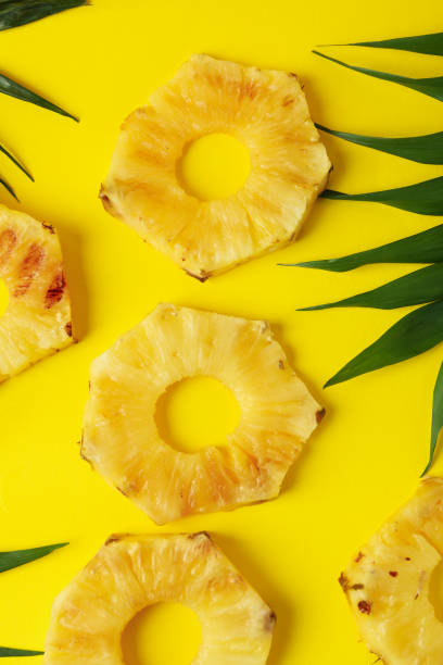 istock Grilled pineapple slices and leaves on yellow background. 1934110867
