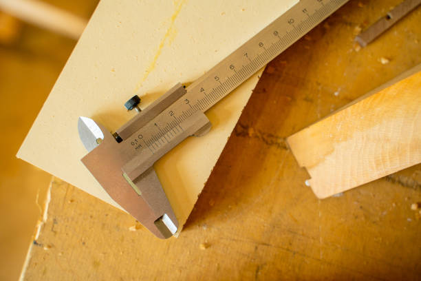 Close-up of a caliper lying on a table in a carpenter's workshop