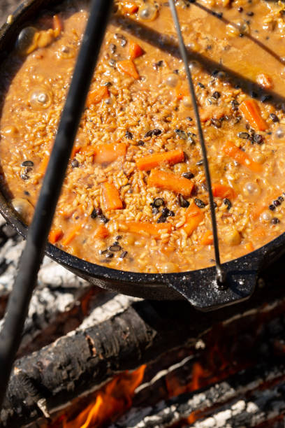 istock Cooking pilaf over a campfire in a tent camp, rice, carrots, spices, mutton 1934171351