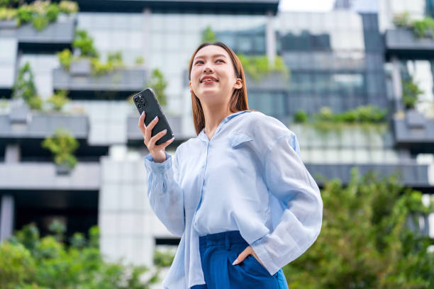 istock Young Asian Woman Working on Phone, Harnessing Wireless Technology Outdoors Seamlessly 1934173434