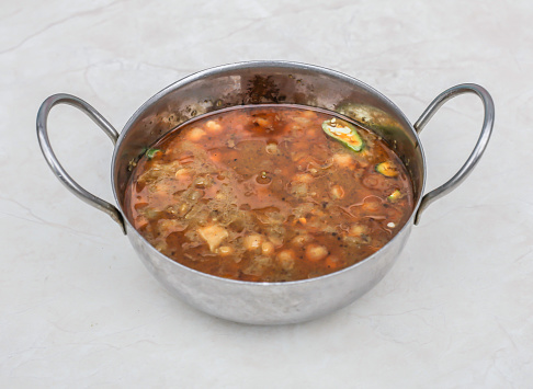 sada chanay, channay, chole or chickpeas curry served in karahi isolated on grey background side view of pakistani breakfast and indian spices food