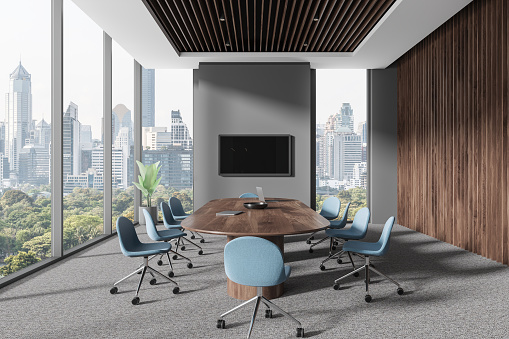 Dark business room interior with board and chairs on carpet. Negotiation workspace with laptop and tv screen, panoramic window on Bangkok skyscrapers. 3D rendering