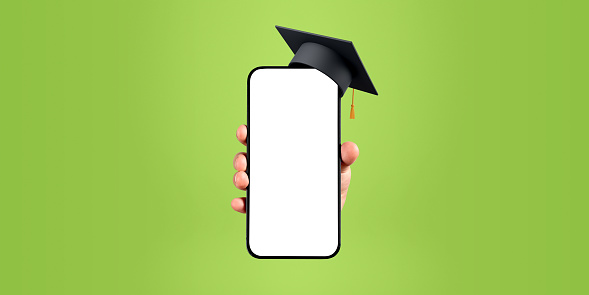 Hand showing a phone mockup copy space screen with graduation hat, green background. Concept of online education, career choice, profession and opportunities