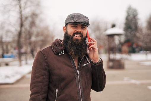 Bearded man talking on the phone in the city
