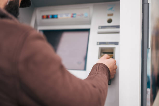 Man using a street ATM machine and withdrawing money