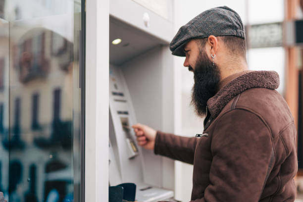 istock Man using a street ATM machine and withdrawing money 1934231173