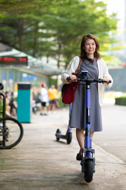 istock Asian woman getting to work with an e-scooter 1934231180