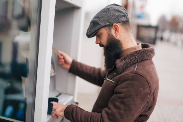 istock Man using a street ATM machine and withdrawing money 1934234352