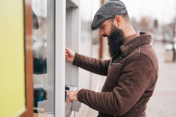 istock Man using a street ATM machine and withdrawing money 1934234380