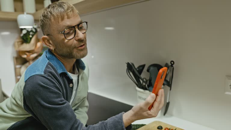 Gay man cooking and talking to partner on video call