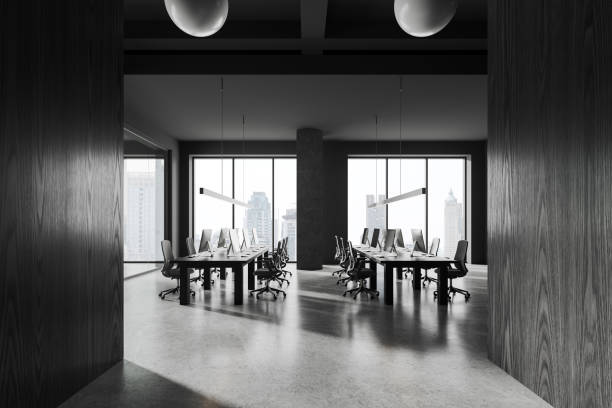 istock Dark office coworking interior with pc desktop and table near window 1934242874
