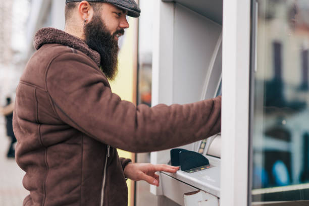 istock Man using a street ATM machine and withdrawing money 1934243952