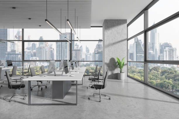istock Coworking interior with desk and pc monitors in row, panoramic window 1934266028