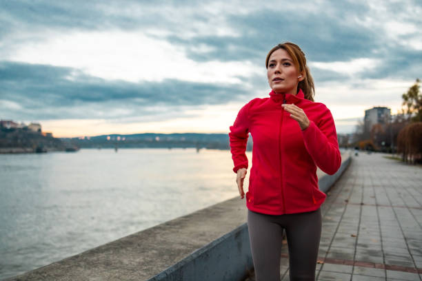 istock Beautiful woman is jogging near river 1934275343
