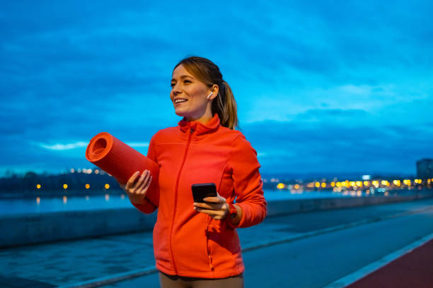 istock Happy athletic woman using mobile phone while walking outdoors. 1934286846