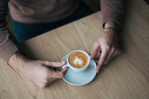 Close-up of male hands holding coffee cup