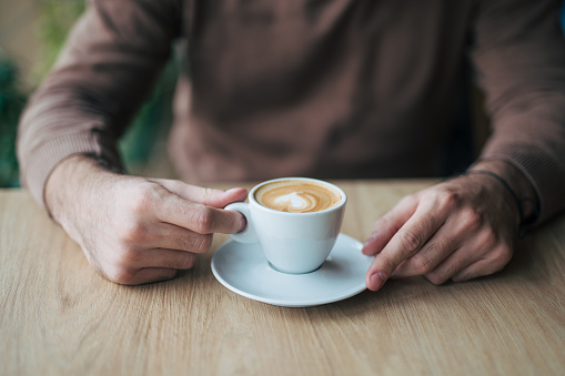 Close-up of male hands holding coffee cup