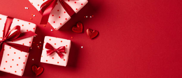 istock Happy Valentine's Day banner design with gift boxes and red hearts on red background 1934320241