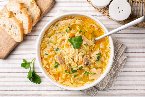 istock Top view of Chicken Orzo Soup in a white plate. Bread. 1934321338