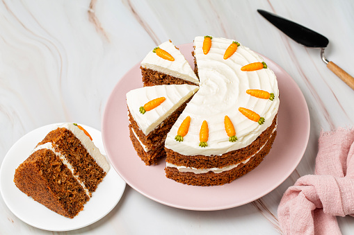 Carrot cake with cream cheese Icing on a rustic white wooden background