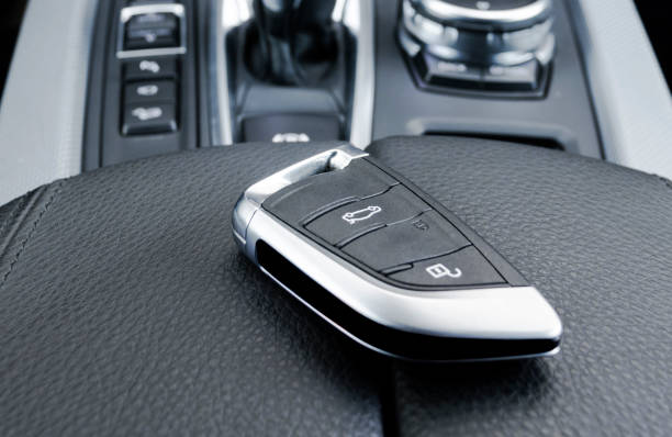 istock Closeup inside vehicle of wireless key ignition. Start engine key. Car key remote in black perforated leather interior. Modern car Interior details. 1934324640