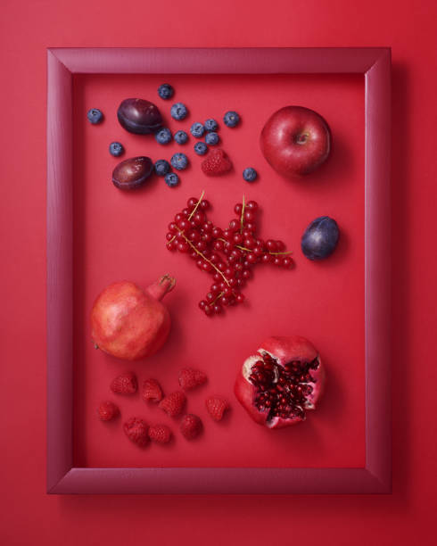 istock Apple, plums, pomegranates, blueberry, raspberry and currant in frame on red 1934333271