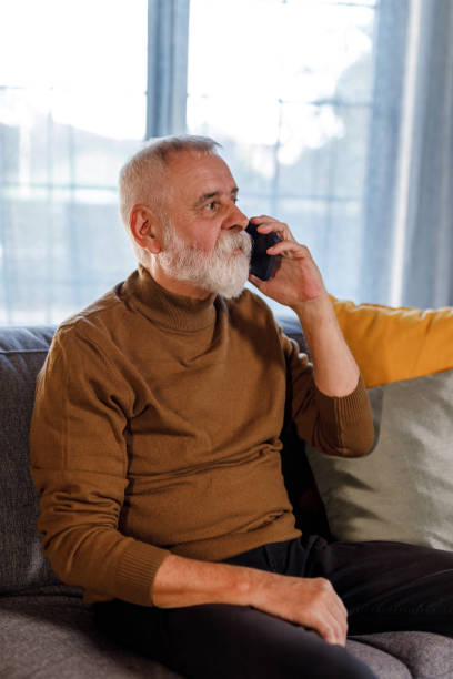 istock Mature man relaxing on the sofa and talking on the phone 1934341044