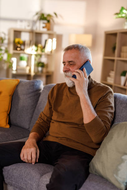 istock Mature man relaxing on the sofa and talking on the phone 1934341048