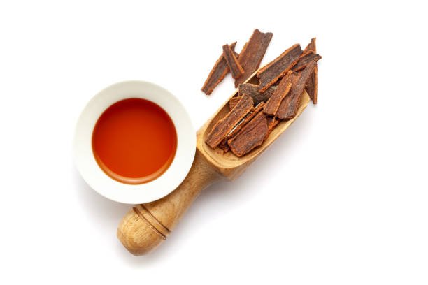 Cinnamon sticks in a white bowl on a wooden background. Its scientific name is Cinnamomum verum and also known as darchini, daruchini, and dalchini. Top view