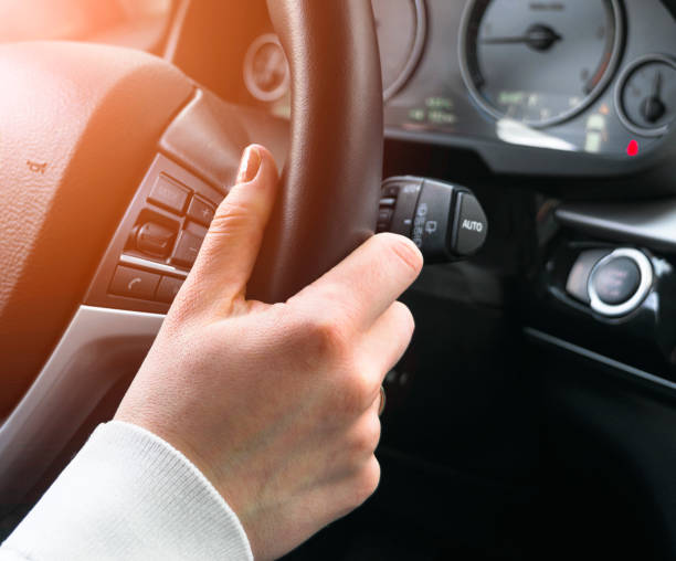 istock Woman's hands on a steering wheel driving. Hands holding steering wheel. Modern Car interior details. 1934359895