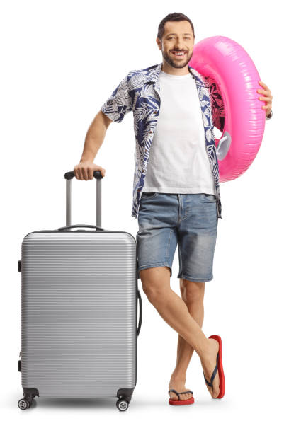 istock Man with a suitcase smiling and holding a swimming ring 1934366867