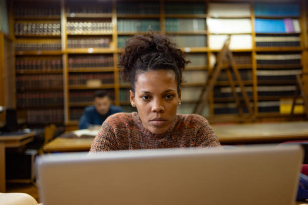istock Concentrated black female student e-learning over laptop in library. 1934389713