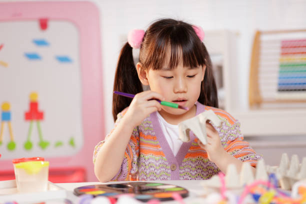 medium shot young girl making craft at home