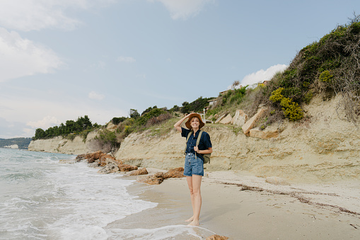 Photo of a young woman exploring the seashore