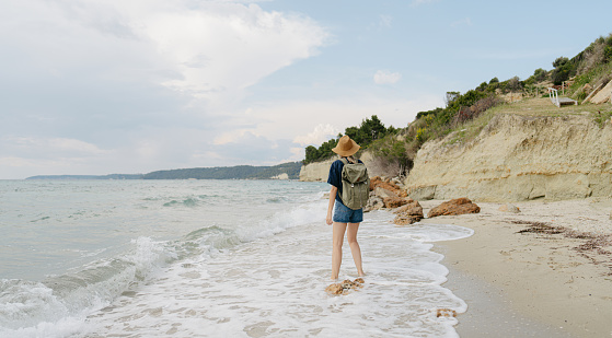 Photo of a young woman having a walk by the sea