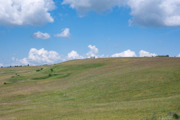 Radome (antenna dome) on the Wasserkuppe with a green meadow and blue sky and copy space