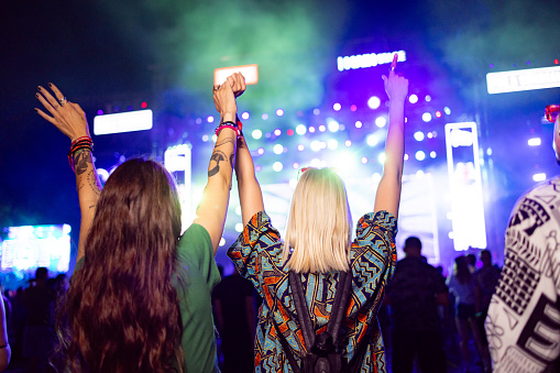 Two female friends drinking beer and having fun at a festival