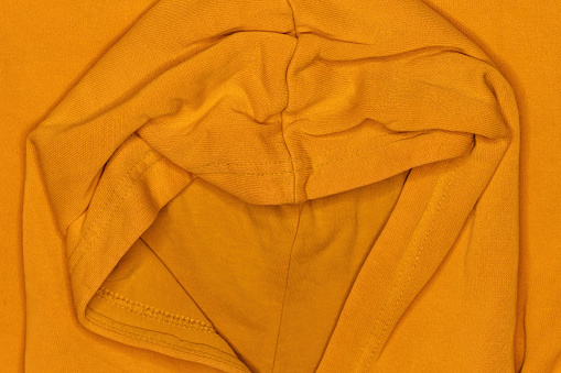 Yellow hooded shirt, top view as background