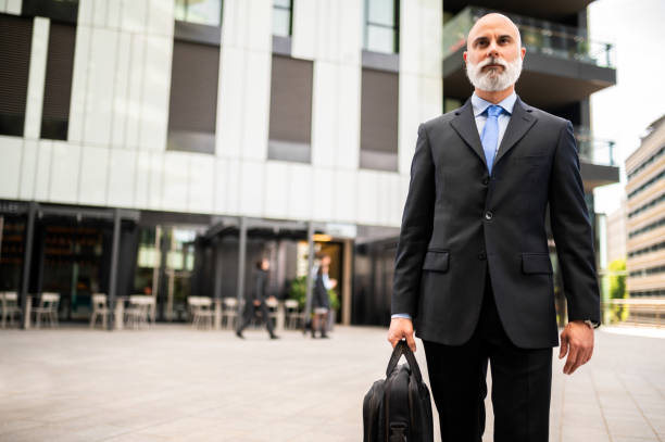 istock Senior stylish bald businessman walking with his bag 1934468074