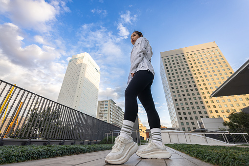 Female athlete standing in city - low angle view