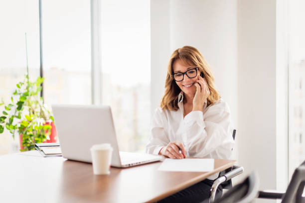 istock Mid aged professional female using laptop and sitting in a modern office 1934481004