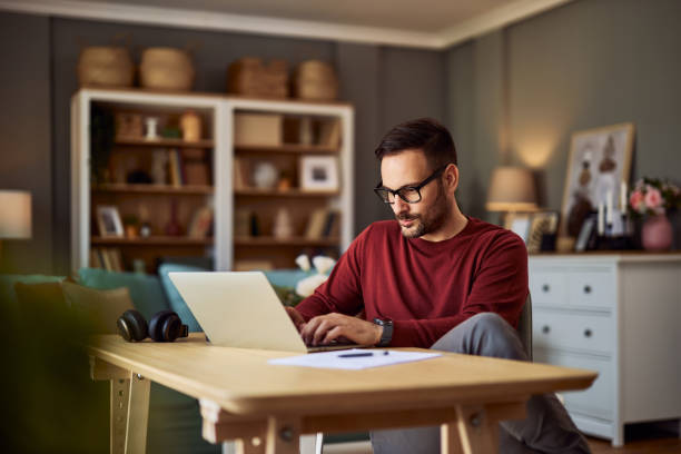 istock A young adult male freelance programmer deep in thought while typing on his laptop and working from home. 1934504020