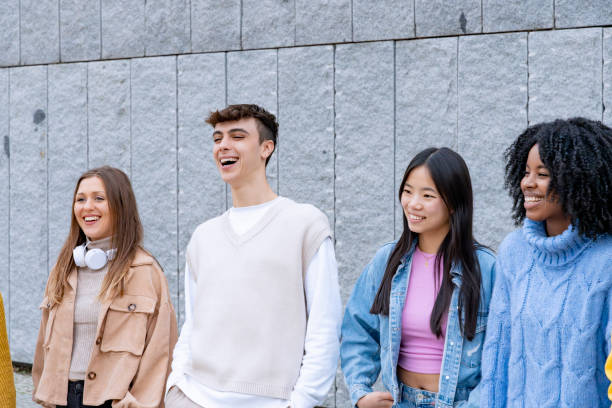 istock Four friends laughing against a concrete wall 1934509548