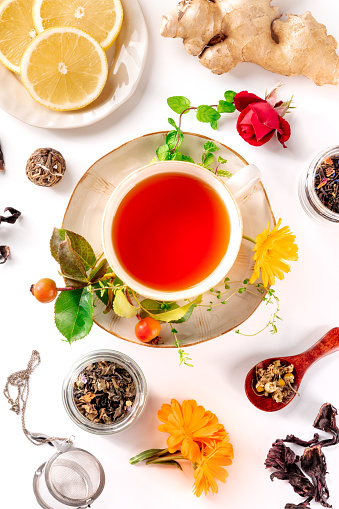 Tea with different ingredients. Herbs, fruits, and flowers, overhead flat lay shot on a white background. Healthy natural remedies