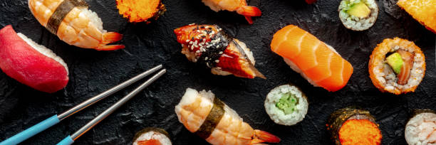istock Sushi with chopsticks panorama. Many rolls, maki, nigiri etc, overhead 1934523155