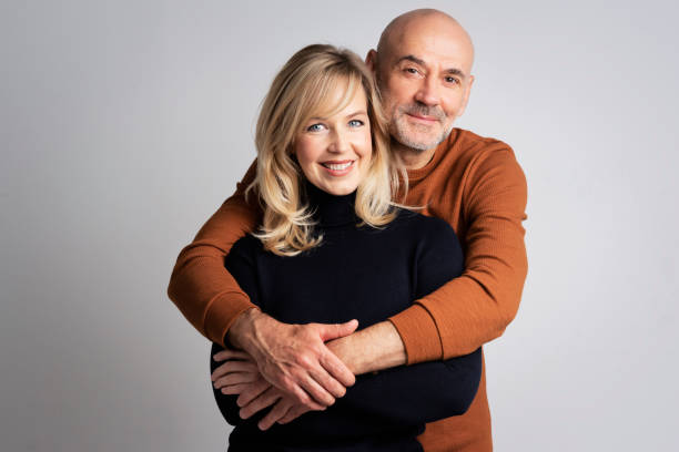 istock Happy couple standing at isolated background embracing each other 1934523184
