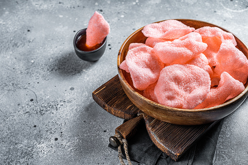 Crunchy kerupuk prawn shrimp crackers, chips. Gray background. Top view. Copy space.